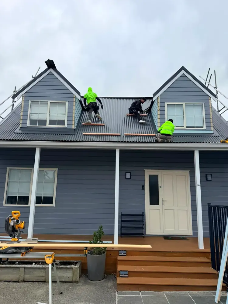 Builders carrying out maintenance and repair work on a roof, Auckland